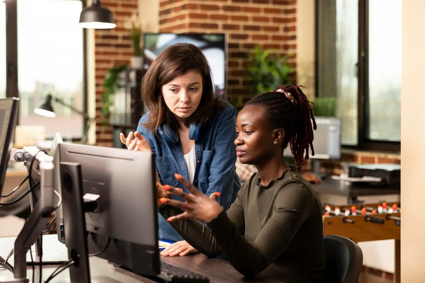 Kollegen beim Brainstorming an einem Desktop-PC