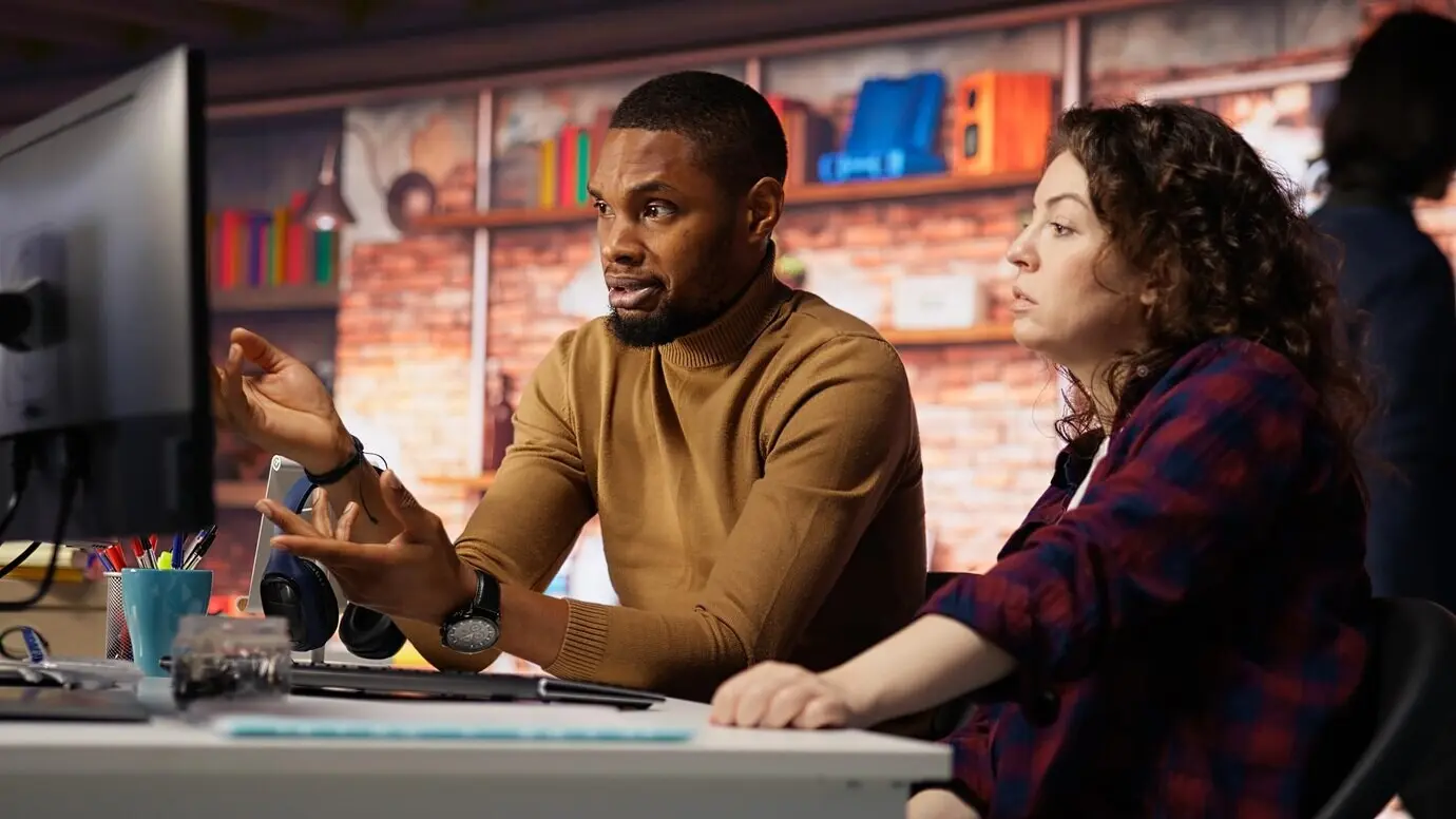 IT-Mitarbeitende in einem Start-up-Büro, die an Computerschreibtischen arbeiten